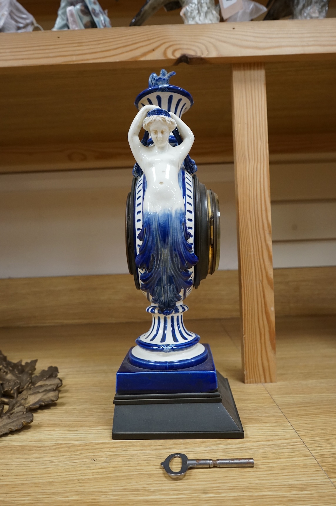 An early 20th century figural glazed ceramic mantle clock, 21cm wide x 40cm high